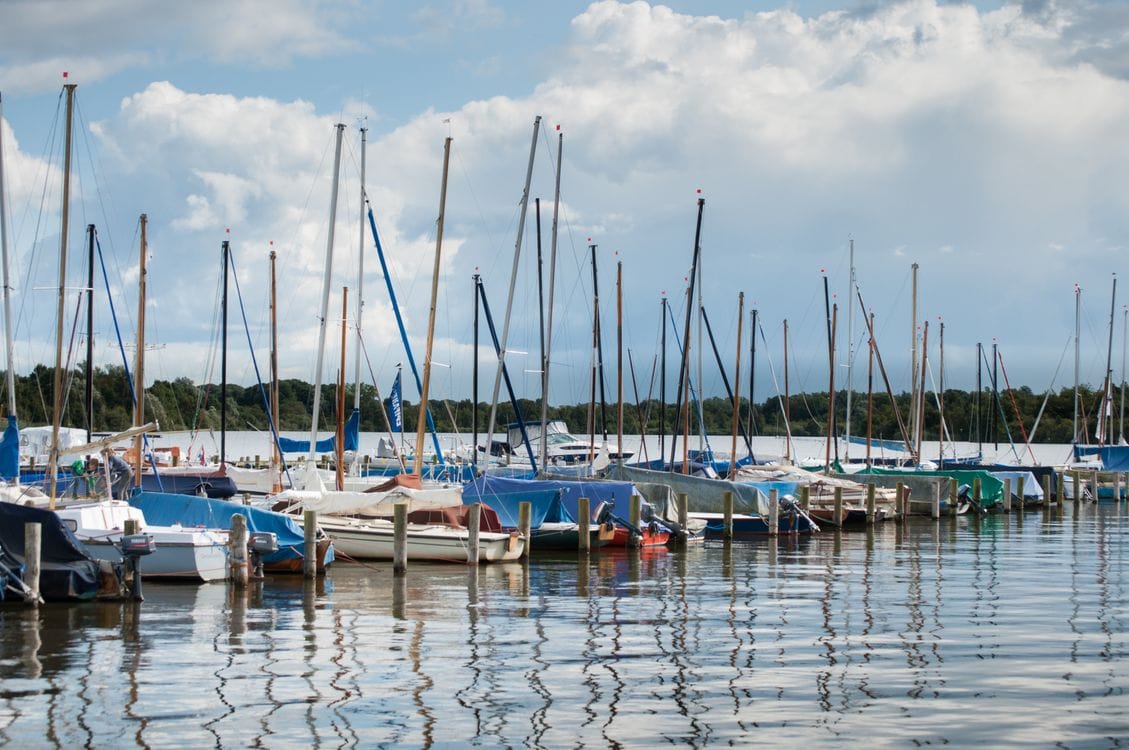 Sejlbåde fortøjet langs kajen i en lystbådehavn