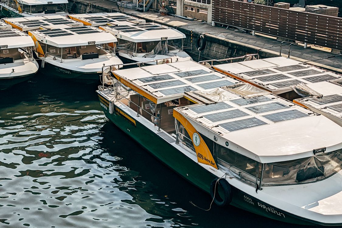 Både med solpaneler monteret på kahytstaget i en marina